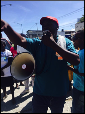 BAI Bertha Fellow Anel Dorzin leads protestors in chants - BAI Bertha Fellow Anel Dorzin conduit les manifestants dans les chants